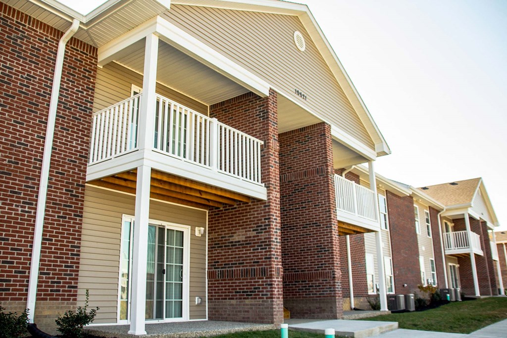 the outside of a brick house with a balcony